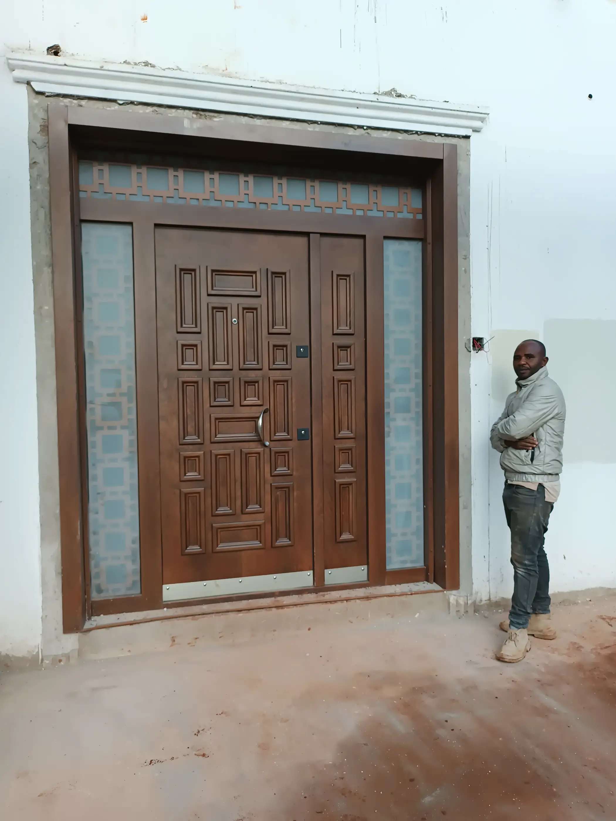 very big natural wood coated steel door with iced glass on the side
